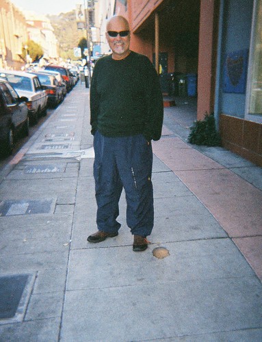 Alfred Arteaga stands next to his poetry plaque in Berkeley