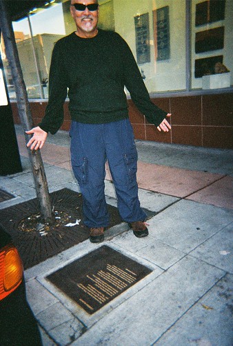 Alfred Arteaga next to his poetry plaque, Berkeley