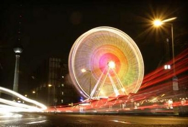 A Ferris wheel is illuminated at a Christmas market in the German capital of Berlin