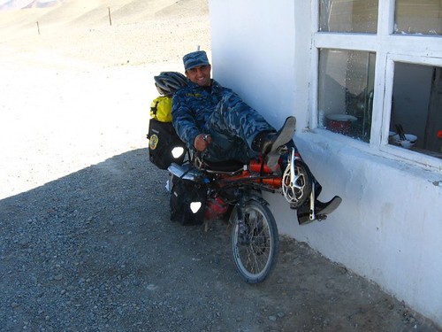 A checkpoint guard tries out the recumbent - near Murghab, Tajikistan / 軍人がリカンベントに乗る(タジキスタン、ムルガブ町)