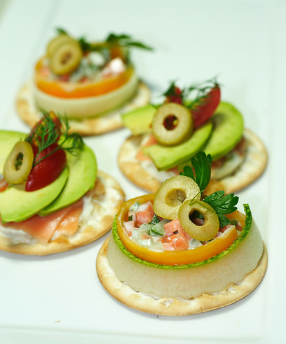 Front: Carrot and cucumber dressed with yogurt and mayoinaise with green olives on table water crackers