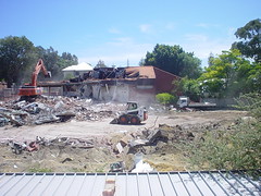 Dust, rubble, machinery, building with most of roof missing