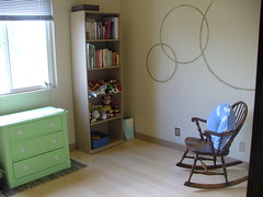 dresser, bookcase, and empty rocking chair in the nursery