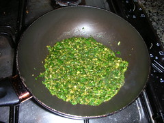 Heating the coriander mixture in a pan.