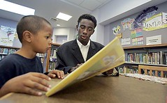 Eric Johnson, 17, a senior at Jefferson High School, helps Andrew Hernandez, 5, with his reading at the Ascot Branch Library