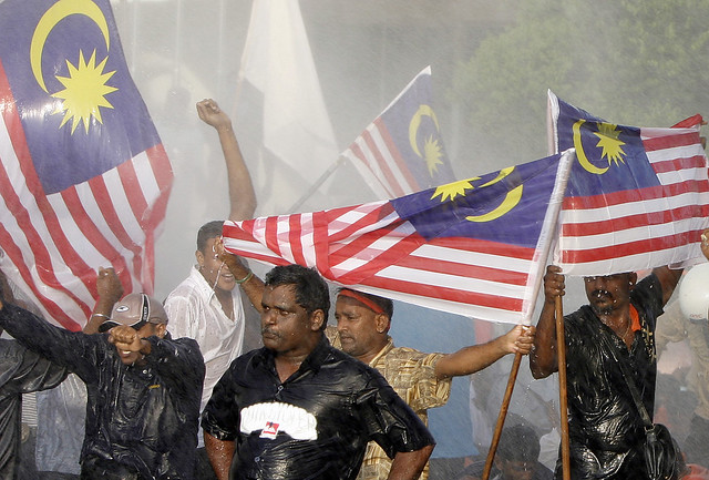  ... malaysian flags while being sprayed with water by malaysian riot
