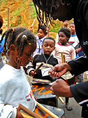 Youth multiplier, Guaraciaba, lovingly tends to the needs of a community child during percussion lessons in the favela