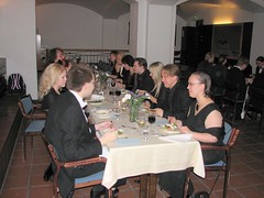People sitting at a long table, enjoying the food