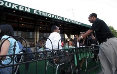 Tefera Zewdie talks to guests outside his restaurant Dukem in Washington,