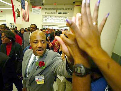 Michael Hardaway, a Wal-Mart store manager, high-fives employees during the grand opening of the Baldwin Hills Crenshaw Plaza store