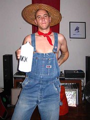 Jacob with straw hat, bandanna, dungarees and bottle of moonshine