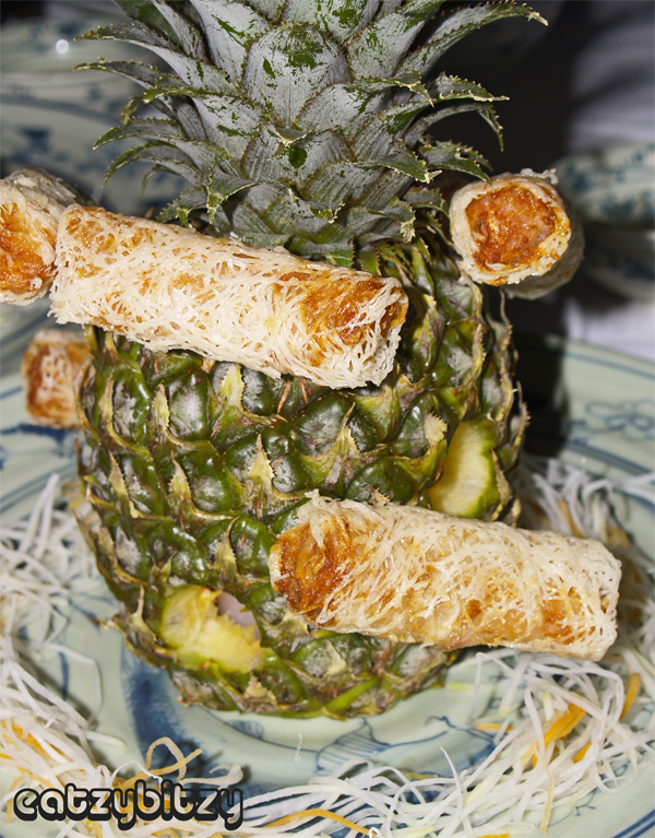  pierced with a toothpick into a hollowed out pineapple, which is lighted 