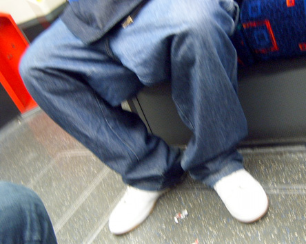 is sitting down in the classic bloke on Tube with legs wide apart way