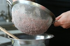 pressing bean paste through a sieve