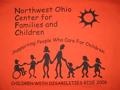 row of cartoon silhouette people holding hands, one in wheelchair, six standing. some seen to be children, some adults