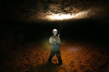 Nathaniel Bluedorn in muddy passage in Mushroom Cave