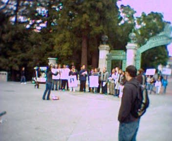 A crowd of LaRouchies held up placards denouncing Cheny while singing medieval counterpoint in front of Berkeley's Sather Gate