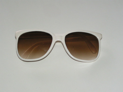 Solglasögon med vita bågar.