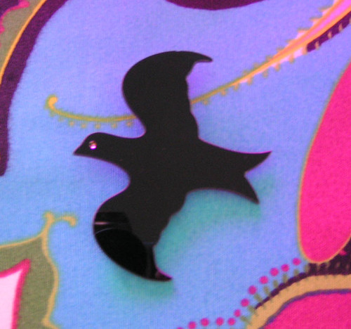Brosch i form av en svart fågel.