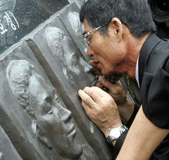 The father of a Korean sailor killed by North Korean gunboats in 2002 touches a bronze relief of his son's face.
