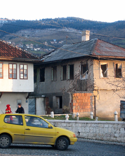 Yellow car, couple and abandoned house