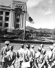 U.S. soldiers supervise the lowering of the Japanese flag at the once-and-future site of Kwanghwamun Palace, 1945.