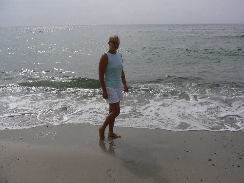Liselotte med krukket benstilling ved stranden