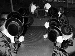 hasidim cover with hats their faces