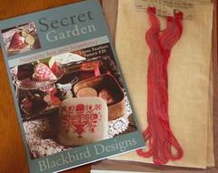 Blackbird Designs Secret Garden with fabric and threads.