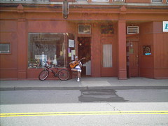 Alex Torres Of The Latin Kings Playing Guitar In Front Of His Music Store.