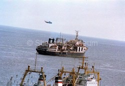 Ukranian factory vessel VOSTOK in Lerwick harbour. Coastguard helicopter above it. 