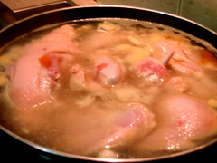 Hainanese Chicken Rice: Chicken cooking in broth.