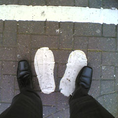Two footsteps painted on the ground by a cash machine