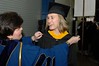 Dean of Students Alicia Finn Helps a Graduate With Her Gown Before Commencement