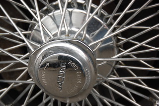 Old Jaguar E-type sports car: hubcap sprocket text "UNDO --> RIGHT (OFF) SIDE"