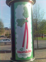 Annonstavla med reklam för Hemköp bestående av tecknade grönsaker med grön blast och röd stjälk